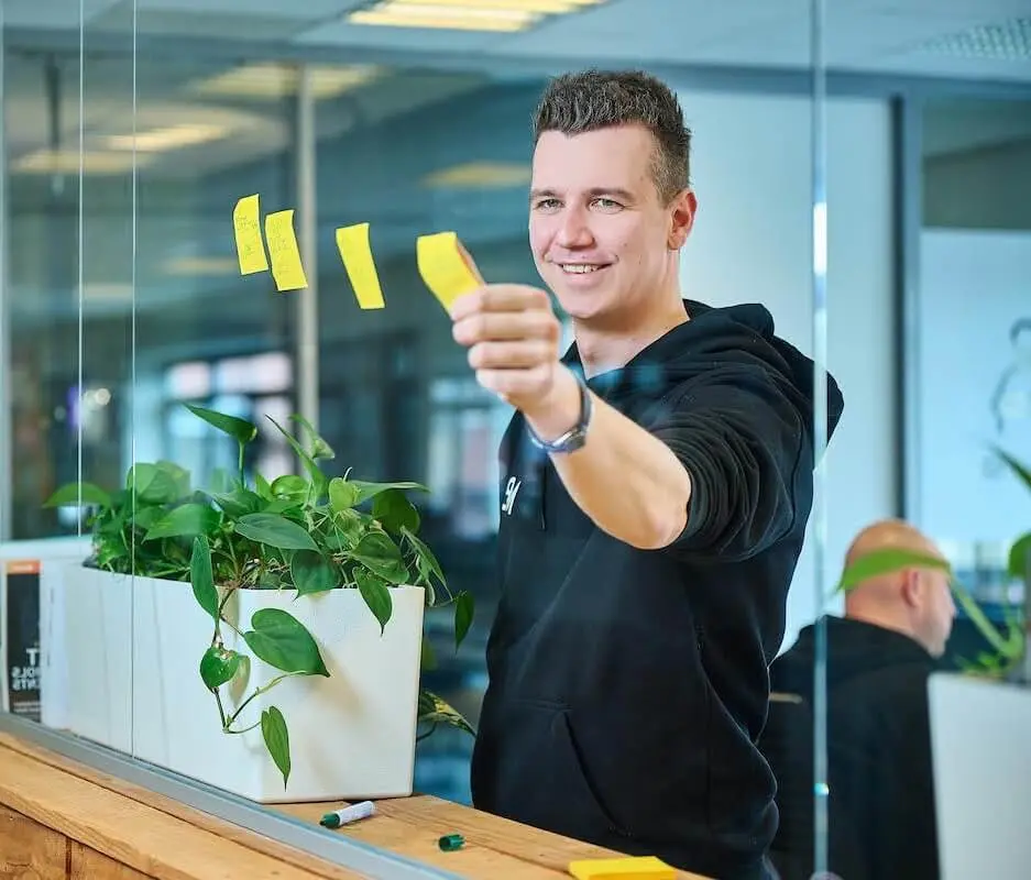 Darius Rosendahl plakt een gele post-it op de studioruit
